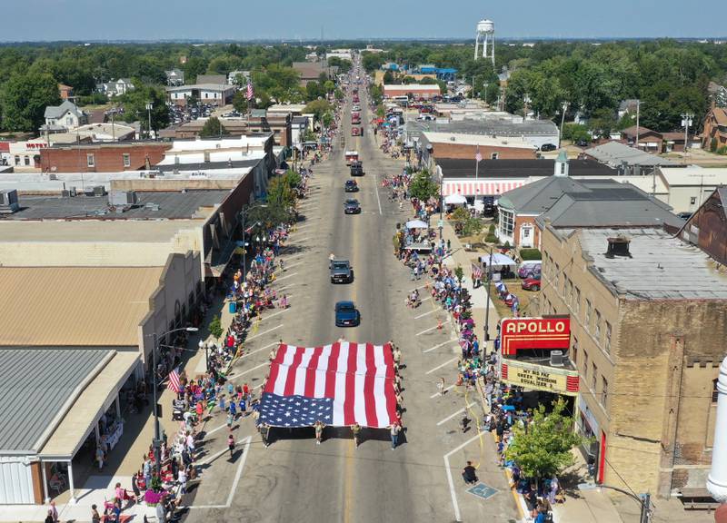 A large American Flag is carried by volunteers down Main Street during the 52nd annual Homestead Festival parade on Saturday, Sept. 9, 2023 in Princeton.