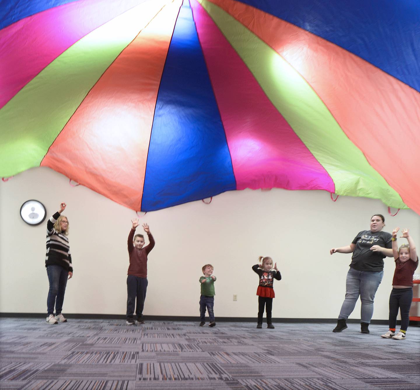Children and parents enjoy themselves during Parachute Play at the Redidick Library in Ottawa Monday. Participants played games and sang songs while using a giant parachute.