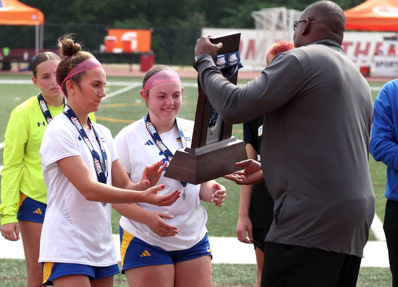 Johnsburg players accept the state second place trophy Saturday, June 7, 2025, after their IHSA Class 1A state championship game loss to Columbia at North Central College in Naperville.