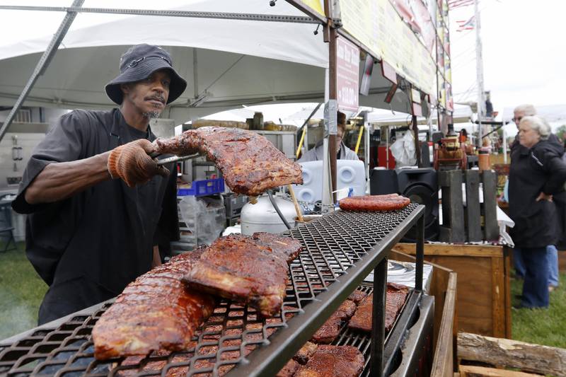 Cowboys Barbecue Grillmaster Marlan Thomas of Fort Worth, TX, grills a slab of ribs during the opening night of the annual Rockin' Ribfest at Sunset Park on Thursday, July 8, 2021 in Lake in the Hills.