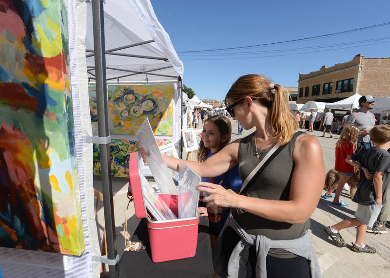 Harper Klaxon and her mother Marissa of La Grange Park admire the work of Heidi Becker while attending the LaGrange Art Festival Saturday, Sept. 9, 2023.