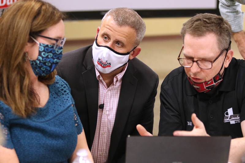 DeKalb mayoral candidate Cohen Barnes, (center) his wife Amy and Faranda's owner Bill McMahon discuss the numbers Tuesday as returns begin to come in during an election night party at Faranda's Banquet Center in DeKalb.