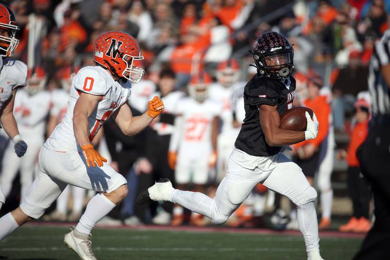 Glenbard East's Amonte Cook (5) heads upfield past Normal's Aiden Boundy (0) for a touchdown during the IHSA Class 7A quarterfinals Saturday November 11, 2023 in Lombard.