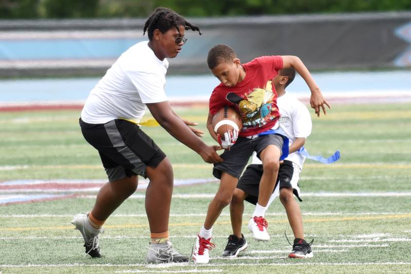 Alvion Floyd, 12, of Kankakee, right, attempts to run from Emery Hamilton, 12, of Kankakee during a game of 7-on-7 at the sixth annual Jonathan Ward Skills Camp at Kankakee High School Saturday, June 14, 2025.