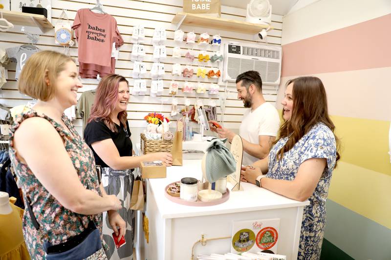 (Left to right) Suzy Ray and Jenni Zielke talk with business owners Tony and Brittany Savatino at Arlo Hendrix Shop during opening day of the Batavia Boardwalk Shops on Friday, May 20, 2022. All businesses are open Fridays, Saturdays, and Sundays through December 18, 2022.