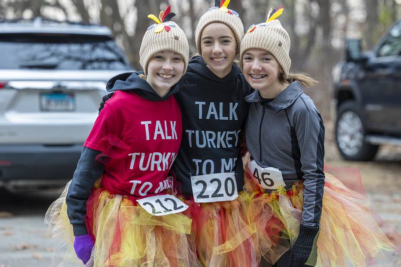 Friends Lauren Wagner (left), Fiona Kelly and Natalie Welty, all of Dixon, gear up properly Thursday, Nov. 28, 2024, for the St. Anne’s Turkey Trot 5K.