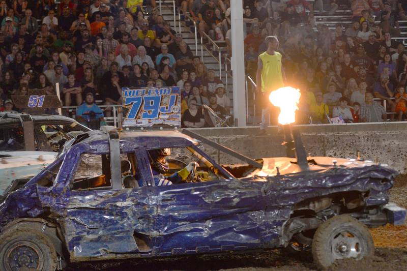 Jeremy Bielema's car shoots flames out of its exhaust during the Open Wire heat at the Whiteside County Fair's demolition derby on Saturday, Aug. 17, 2024.