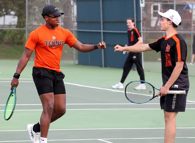 DeKalb number one doubles team Matthew Williams (left) and Ryan Lottes fist bump after a point Thursday, April 24, 2025, during their match at Sycamore High School.