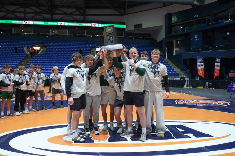 Coal City wrestlers hoist the IHSA Class 1A Dual Team State championship trophy following their victory over Vandalia on Saturday, Feb. 28, 2026.