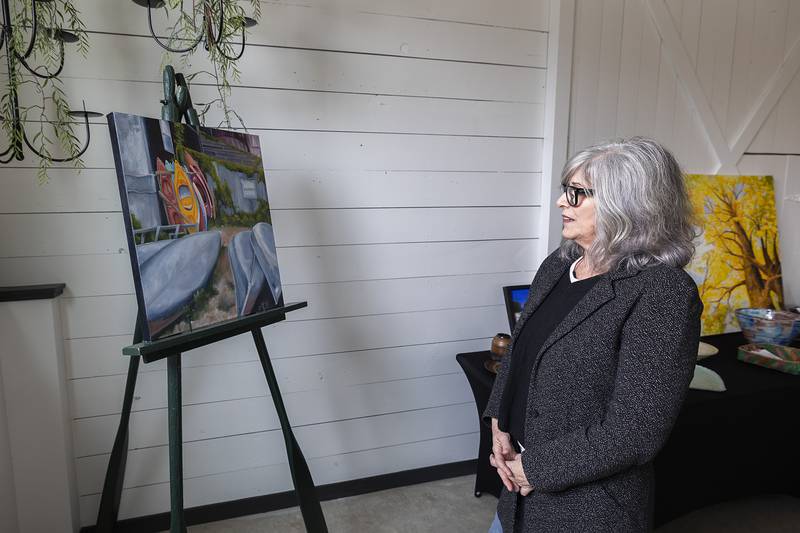 Karen Tucker of Grand Detour talks about the painting she submitted to Serenity Hospice and Home’s Art Dash fundraiser Wednesday, April 10, 2024 in Oregon. Those attending the fundraiser had a chance to grab one of 92 pieces of art from 75 artists.