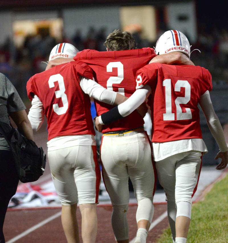 Oregon's Cooper Johnson (2) is helped off the field by two teammates in the first half of the Hawks' Homecoming game with Rock Falls on Friday, Sept. 19, 2025 at Landers-Loomis Field in Oregon.