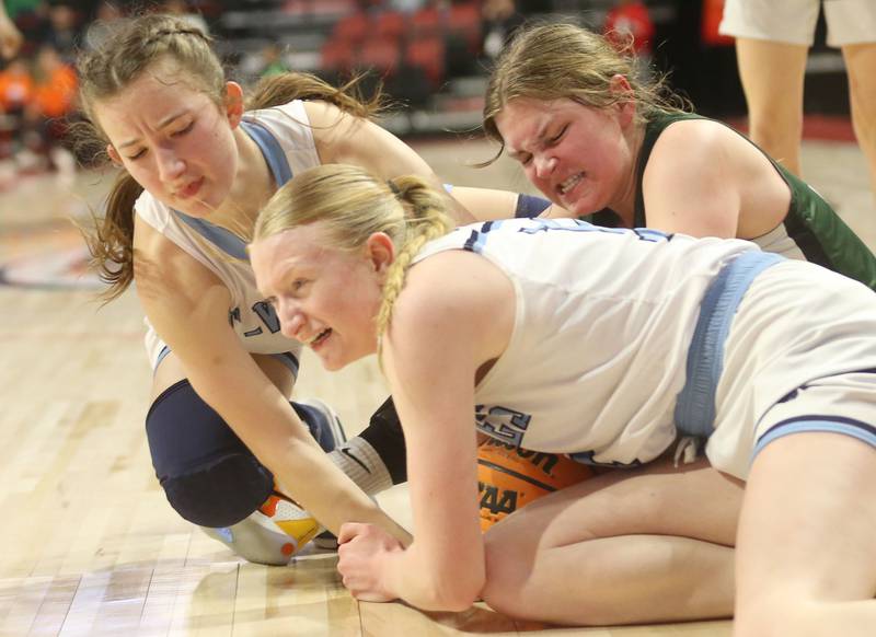 Cissna Park's Sophie Duis grabs a loose ball with the help of teammate Julie Edelman as St. Edward's Maggie Jazemsky fights to free it during the Class 1A third place game on Friday, March 7, 2025 at CEFCU Arena in Normal.