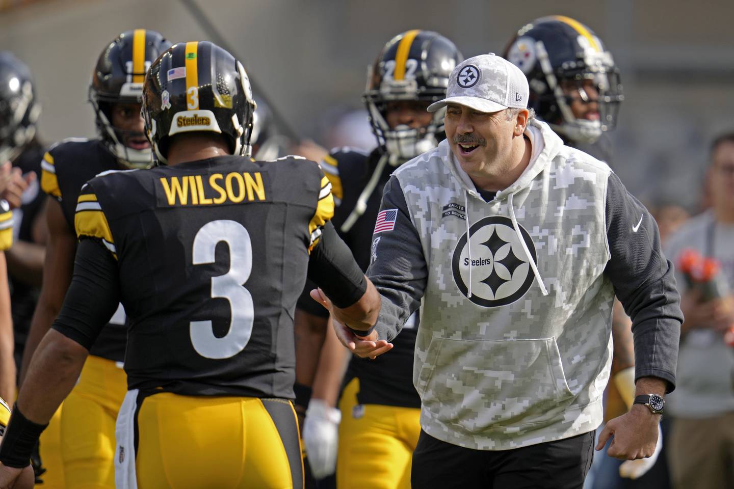 Pittsburgh Steelers offensive coordinator Arthur Smith, right, shakes hands with quarterback Russell Wilson (3) during warm ups before an NFL football game against the Baltimore Ravens, Sunday, Nov. 17, 2024, in Pittsburgh. (AP Photo/Gene J. Puskar)