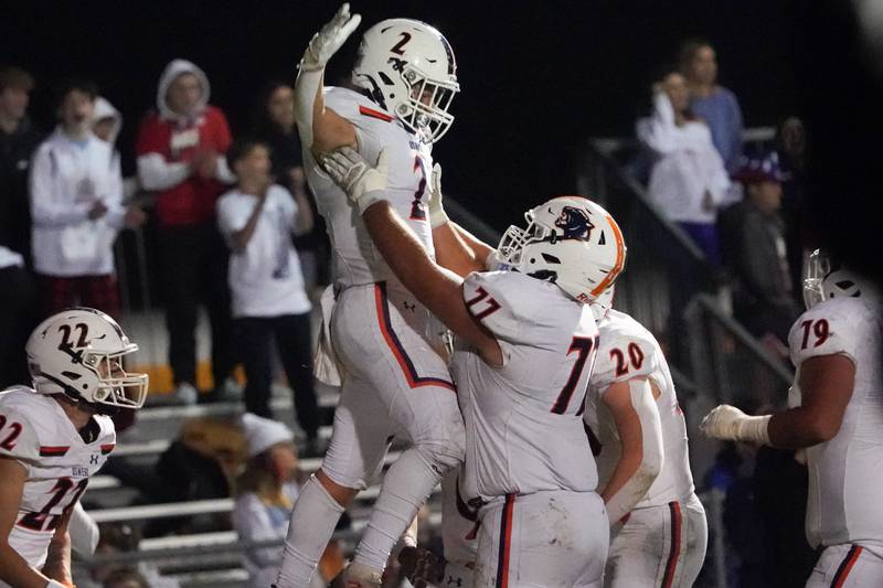 Oswego’s Lucas Andersen (2) celebrates with Benjamin McCollum (77) after scoring his second touchdown of the game against Oswego East during a football game at Oswego East High School on Friday, October 25, 2024.