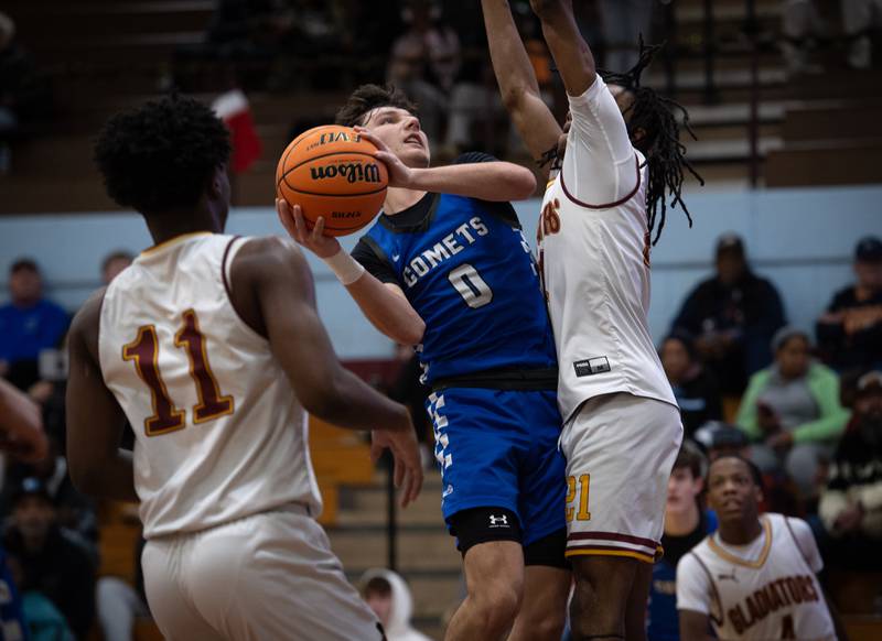 Clifton Central's Derek Meier, center, elevates for a shot as Christ the King's Amarion Dates, right, guards during a game in the Kankakee Holiday Tournament at Kankakee High School on Saturday, December 27, 2025.