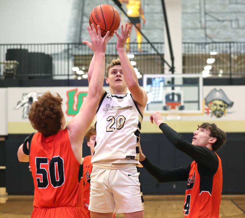 Sycamore's Thatcher Friedrichs shoots between two Sandwich defenders during their game Friday, Nov. 24, 2023, in the Leland G. Strombom Holiday Tournament at Sycamore High School.