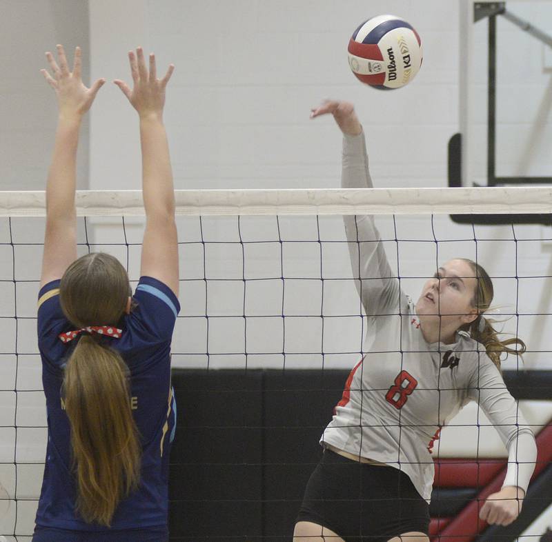Woodland’s Grace Longmire leaps to get a spike past Marquette’s Kelsey Cuchra  in the 1st set Thursday at Woodland.