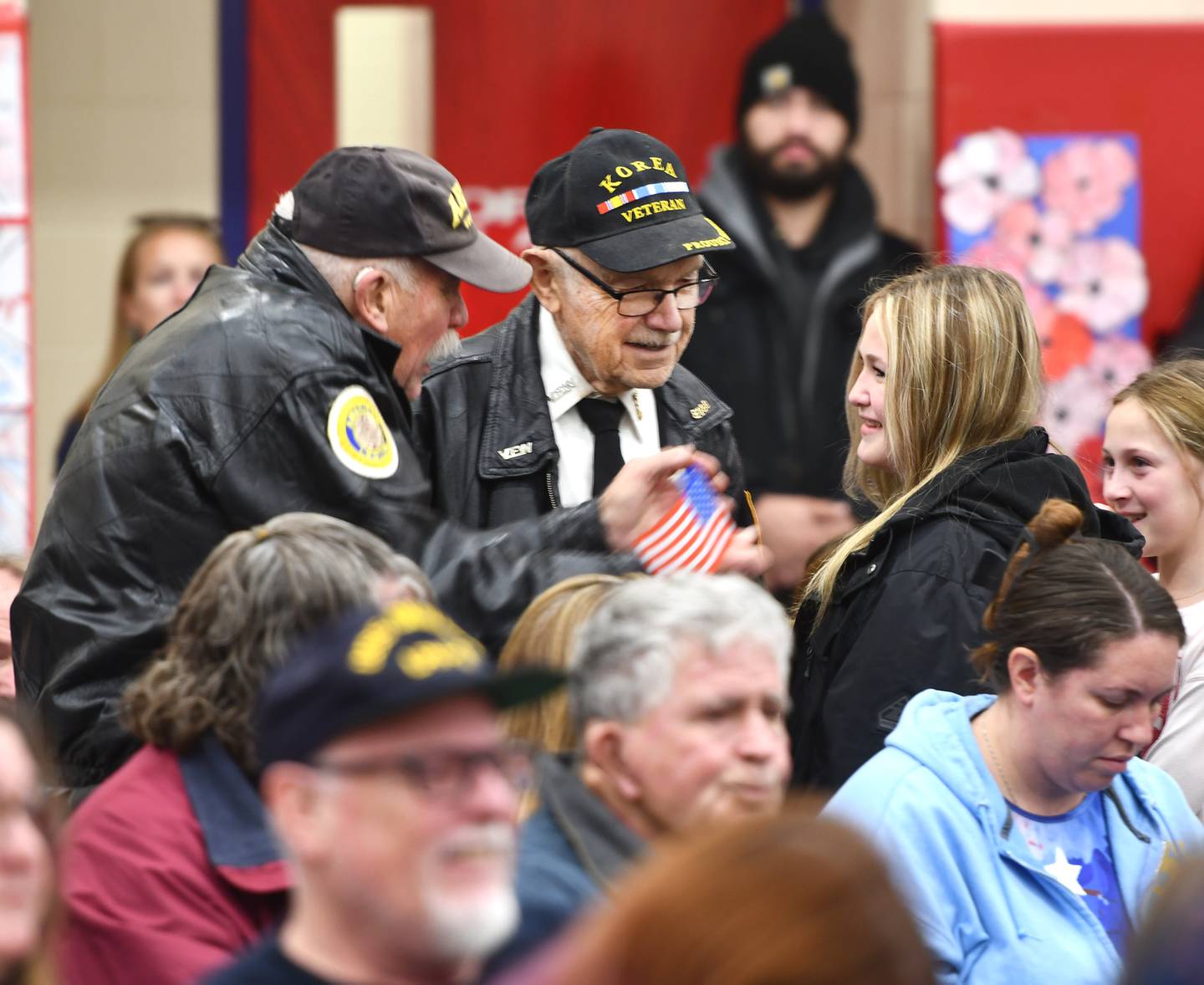 Veterans John Tuttle (left) and Stan Eden receive flags during the Oregon School District's Veterans Day Assembly on Tuesday, Nov. 11, 2025. The event was held Tuesday morning in the Blackhawk Center to thank veterans for their service.