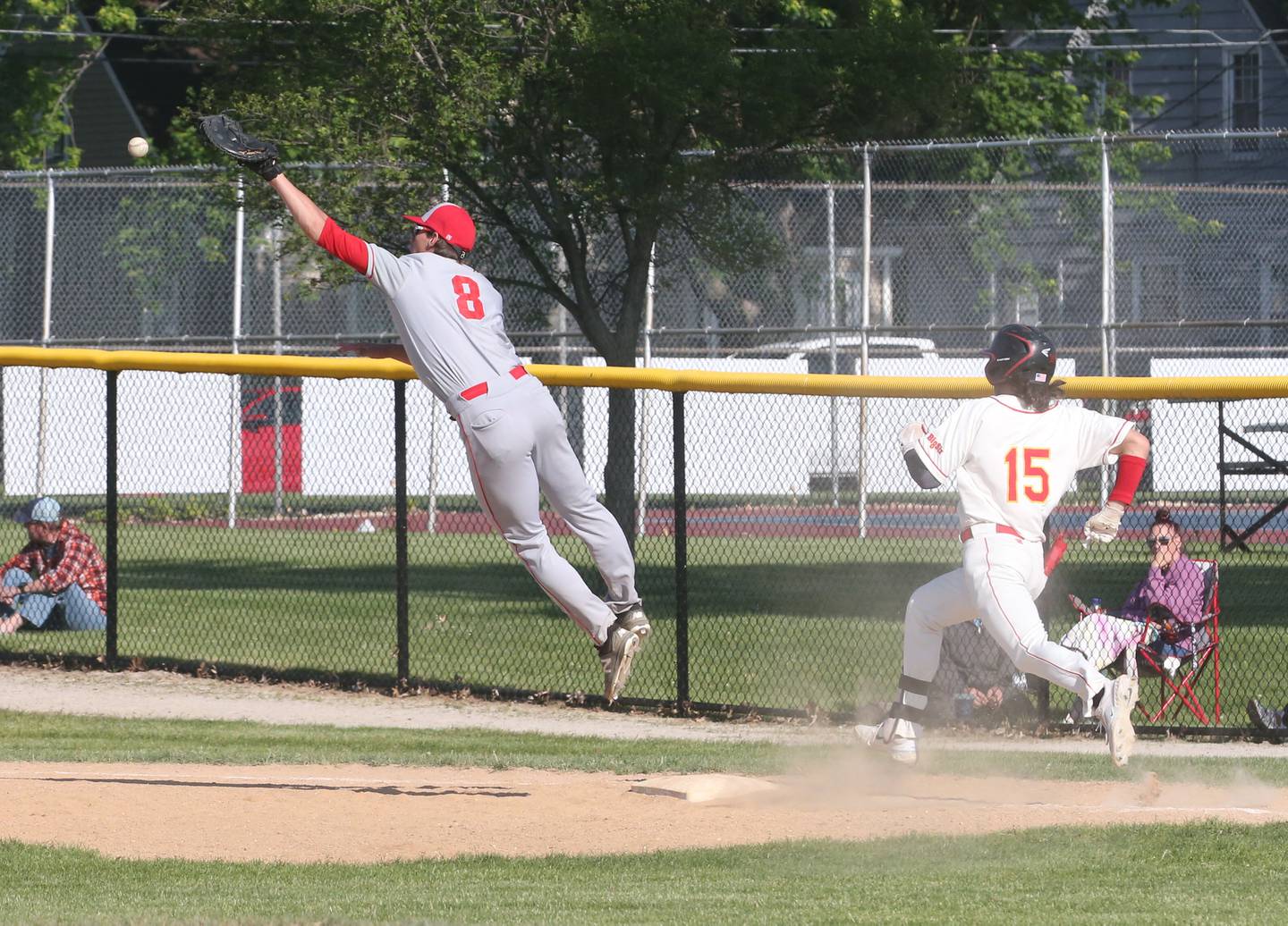 Ottawa first baseman Rylan Dorsey can't reach a high throw while Rock Island's Conner Dilulio reaches first base during the Class 3A regional semifinal Thursday, May 25, 2023, at Morris High School.