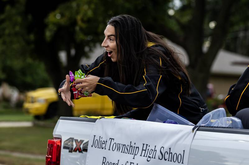 JTHS board member Lorena Guerrero passes out candy to spectators on Glenwood Ave. in Joliet during the Joliet West homecoming parade on Oct. 10, 2025.
