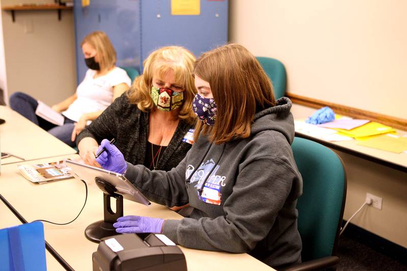 Election Judges Mia Norris and Beth McNeeley assist a voter at the polling place at the Downers Grove Village Hall on Nov. 3.