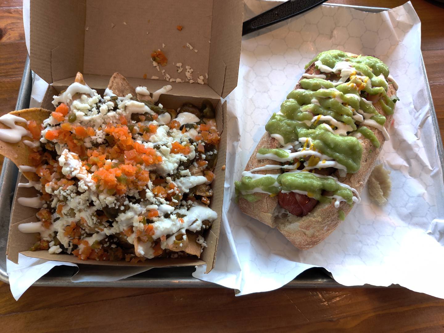 A side order of the house nachos is served with the Sonoran hot dog at the newly opened Nacho Burger, next door to its sister establishment, Bien Trucha, in downtown Geneva.