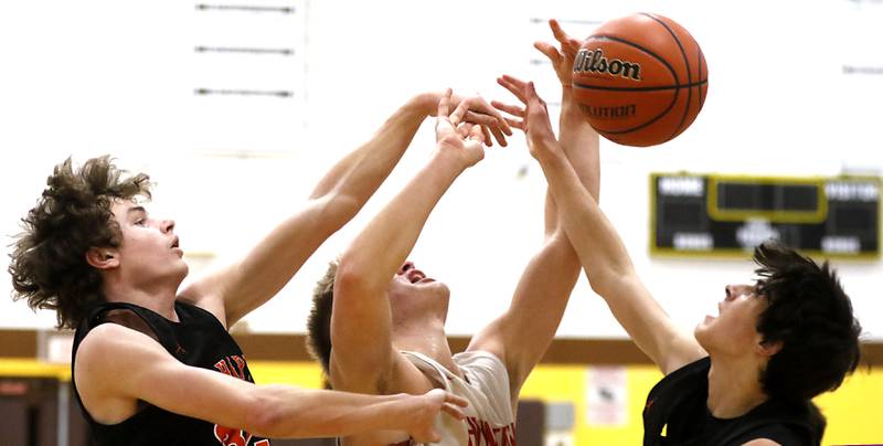 Huntley's Aiden Wieczorek, center, battles for a rebound with McHenry’s Anthony Fowler, left, and Marko Visnjevac, right, during a IHSA Class 4A Boys Regional basketball game Wednesday, Feb. 23, 2022, between Huntley and McHenry at Jacobs High School.