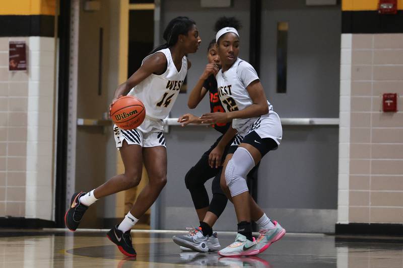 Joliet West’s Destiny McNair (14) works around a successful pick by teammate Makayla Chism against Plainfield East on Thursday, February 2nd.