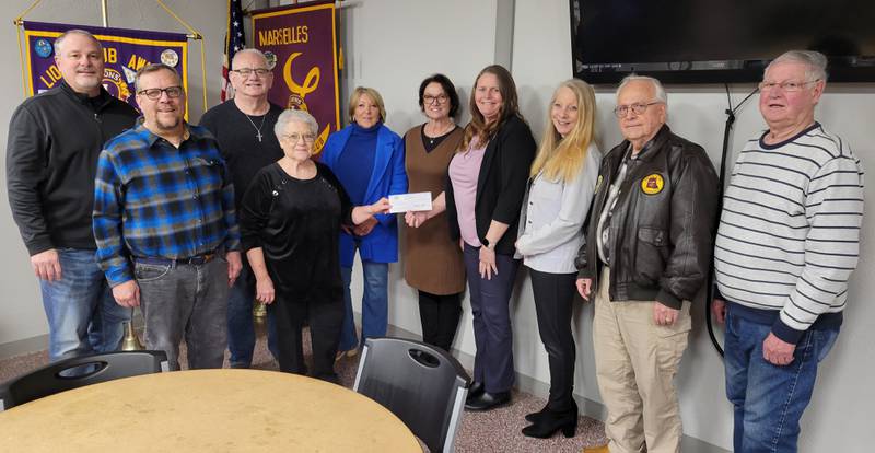 Marseilles Nursing Service secretary Carol Downey (fourth from left) on Tuesday accepted donations of $8,300 from the Marseilles Rotary and $3,000 from the Lions Club to benefit the service's work. Also present for the donation were (from left) Lions treasurer Shane Trager, Lions president Brock Martin, Marseilles Mayor and Service board member Jim Hollenbeck, Service board member Sharon Swanson, Nursing Service nurse Kathy Rosengren, Marseilles Lions Club president and Nursing Service treasurer Sherri Lattilo, Service board member Pam Haug, Rotary treasurer Hank Roe and Rotary member Don Weber.