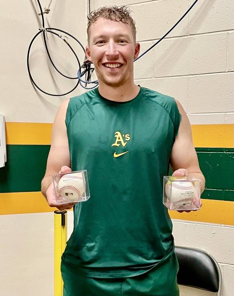 Brett Harris shows the two baseballs that he hit out of the park for a pair of home runs in just his second Major League game with the Oakland A's. He is the son of former Ohio High School basketball all-stater Lance Harris.