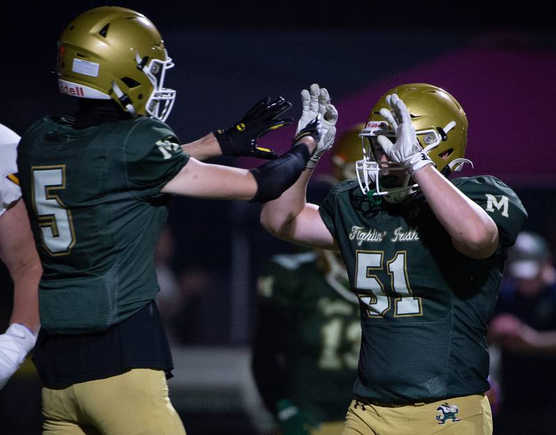 Bishop McNamara's Richie Darr, left, and Mason Hemenover, right, give each other high-fives after a touchdown in a game against Chicago Christian on Friday, September 19, 2025.