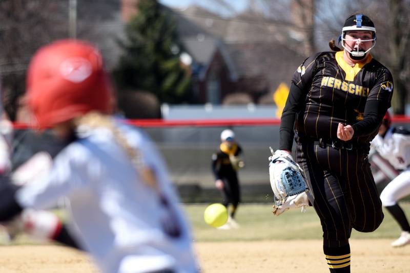 Herscher's Anistin Hackley, right, throws a pitch to Bradley-Bourbonnais' Bella Pusateri during a game at Bradley-Bourbonnais Monday, March 24, 2025.