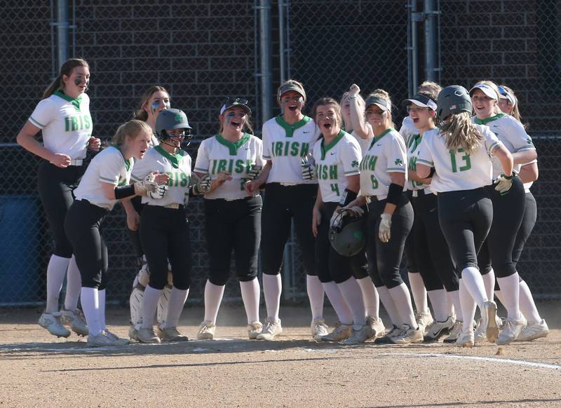 Seneca's Kennedy Hartwig (right) runs to home plate as she is greeted by her teammates after hitting a home run against Putnam County on Thursday, April 13, 2023 at Seneca High School.