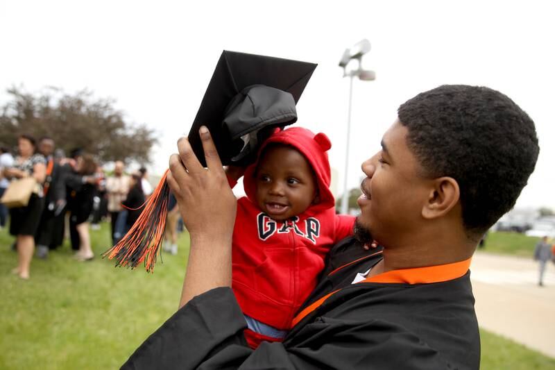 St. Charles East graduate Chadlin Dunlap-Milam shares his cap with his cousin, Micah Patterson, 1, following the school’s commencement ceremony at the Northern Illinois University Convocation Center in DeKalb on Monday, May 23, 2022.