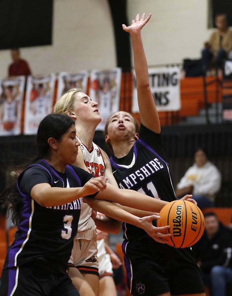 Crystal Lake Central's Ruby Macke (center) drives to the basket against between  Hampshire's Jiselle Lopez (left) and Hampshire's Mikala Amegasse  during a a Fox Valley Conference basketball game on Friday, Feb. 7, 2025, at Crystal Lake Central High School.