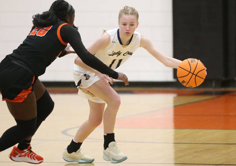 Marquette's Keely Nelson dribbles around Peoria Manual's Breyasia Grayson during the Falcon-Irish Thanksgiving Tournament on Monday, Nov. 18, 2024 at Flanagan High School.