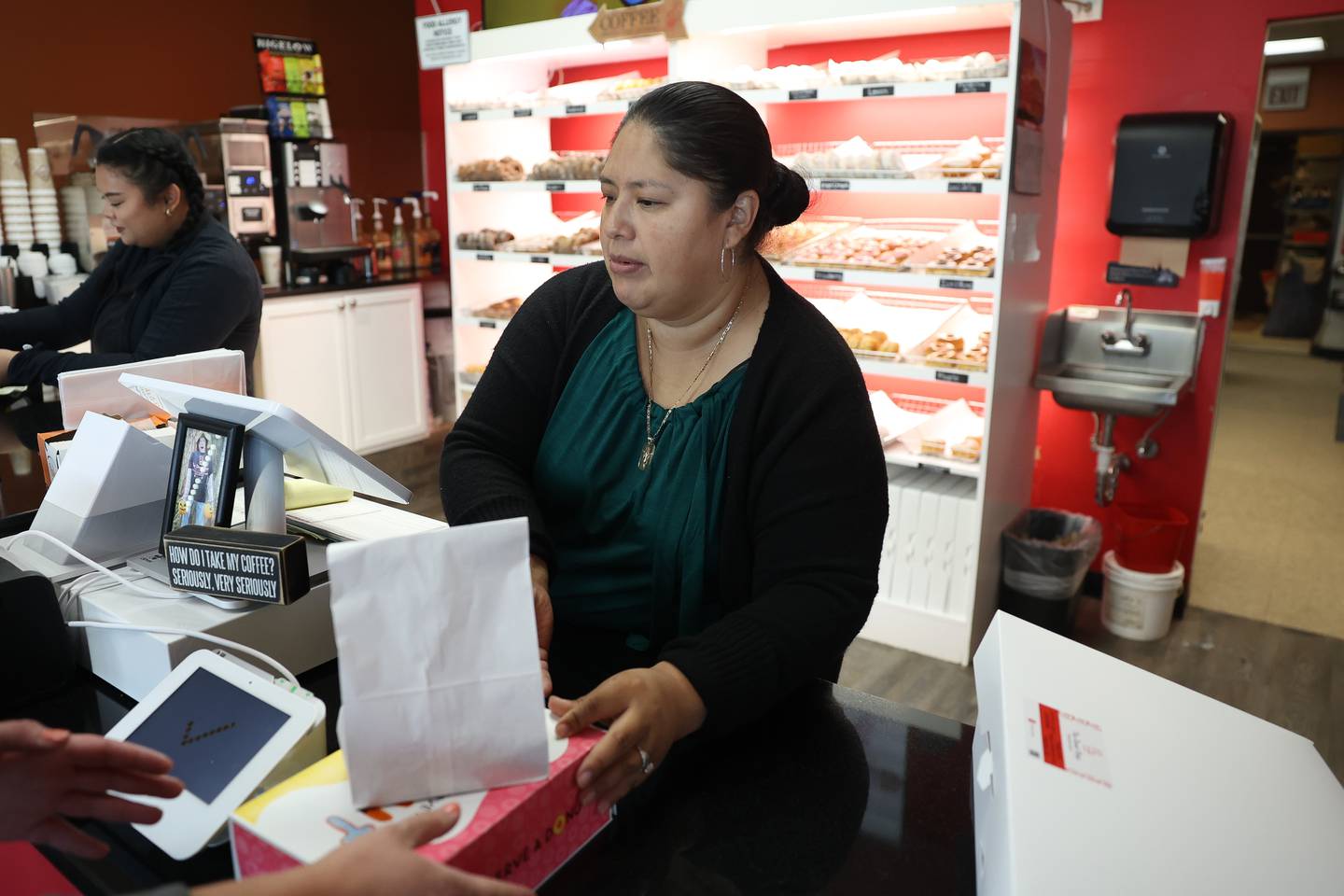 Edith Medina, owner of The Donut Shop, rings up a costumer on Wednesday, Sept. 13, in Lockport.