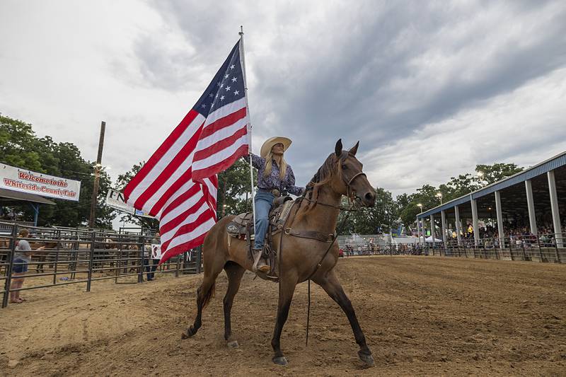 Flag bearer Laynee Noble of Poplar Grove rides the colors around the rodeo ring Wednesday, Aug. 14, 2024, at the Whiteside County Fair in Morrison.