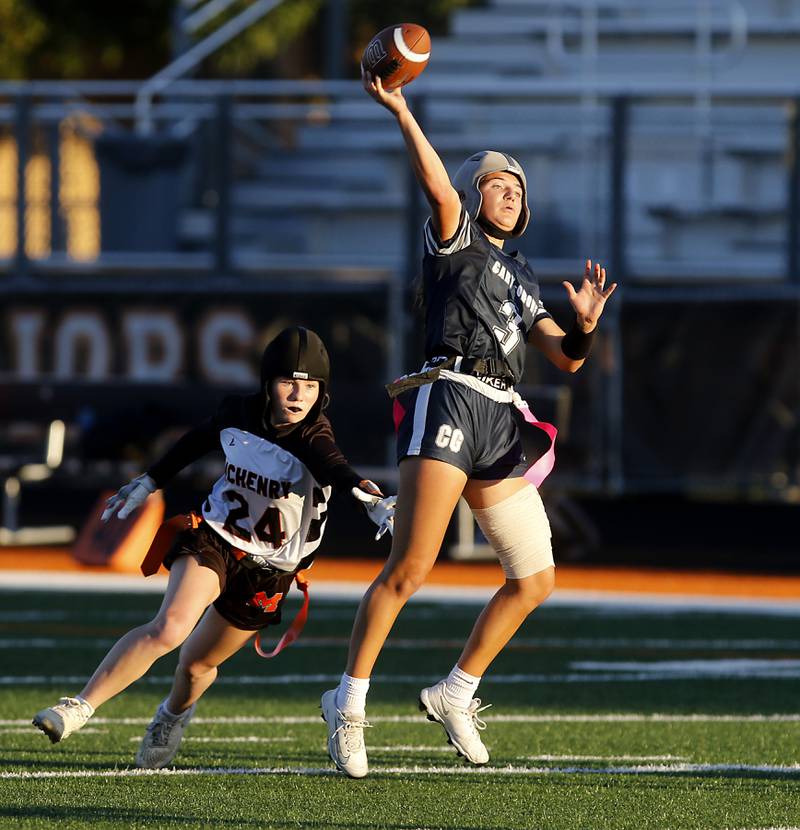 Cary-Grove's Kennedy Manning throws a touchdown bpass as \mh24 tries to grab her flag during the IHSA McHenry Regional girls flag football championship game on Wednesday, Oct. 8, 2025, at McCracken Field in McHenry.