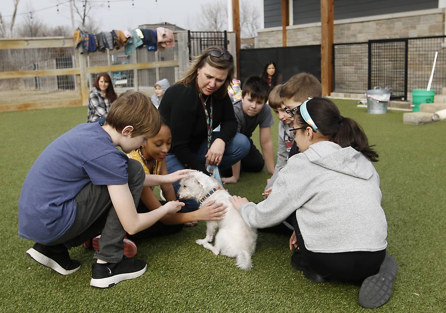 Jennifer Waldack, a fourth grade teacher at Mary Endres Elementary School, interacts with her students and a dog at Young At Heart on Tuesday, March 21, 2023, during a field trip to the senior animal rescue facility. Waldack helps run her school's Difference Makers program.