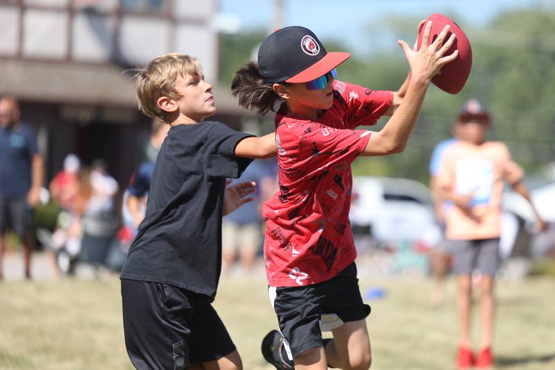 Joe Lardi, 11-years old, catches a pass against his friend Dustin Rys, 10-years old, in a game of football before the start of the Manhattan Labor Day Parade on Monday, Sept. 4, 2023 in Manhattan.