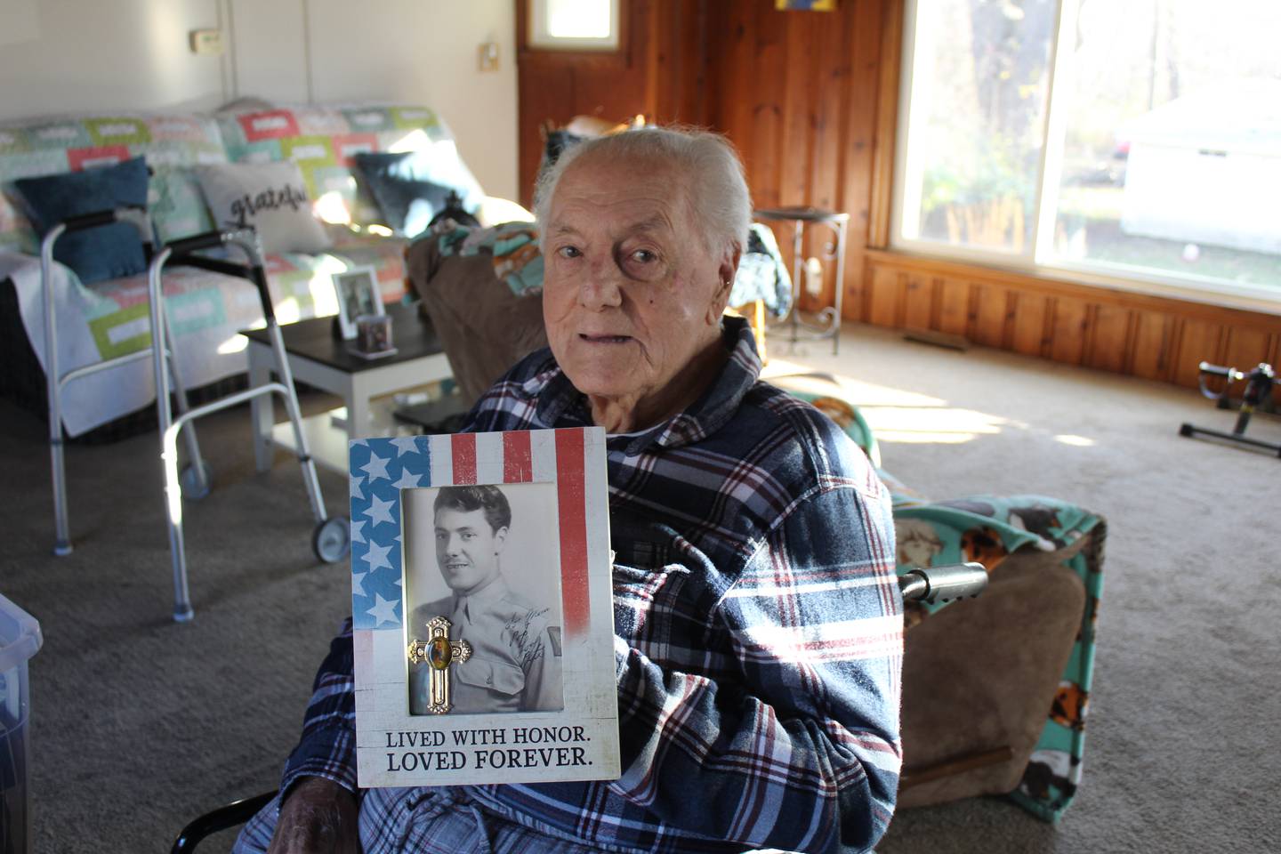World War II veteran Peter Cirelli holds a photo of himself when he enlisted in the Army.