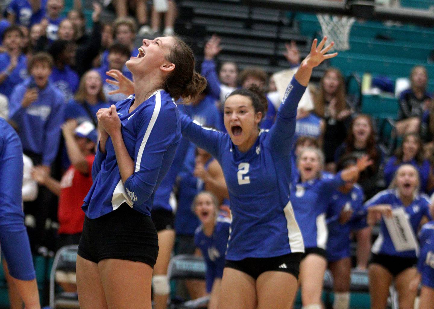 Woodstock’s Hallie Steponaitis, left, enjoys the moment as the final point falls in a two-set win in varsity volleyball at Woodstock North Monday night. Coming in to join the celebration is Ava Sieck, right.