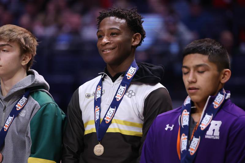 Joliet Catholic’s Gylon Sims is all smiles as he takes the  podium as the Class 2A 113lb. champion at State Farm Center in Champaign. Saturday, Feb. 19, 2022, in Champaign.