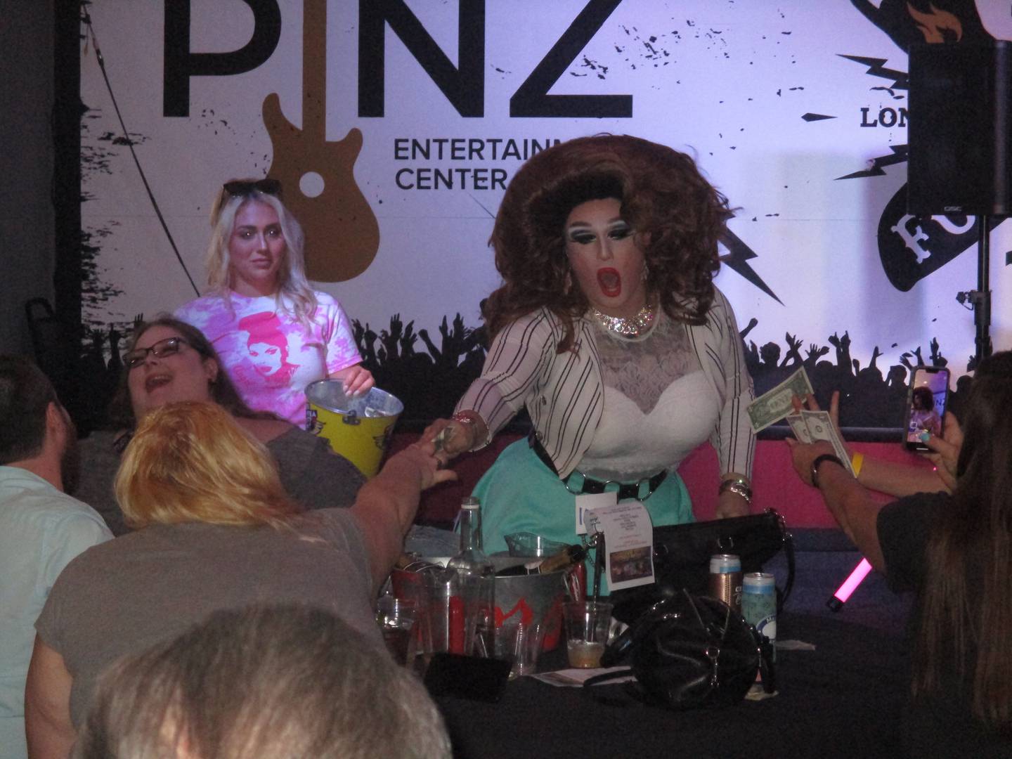 Performer Fox E. Kim receives dollar bill tips from patrons during the drag show at Pinz Entertainment Center in Yorkville on Aug. 21, 2022.
