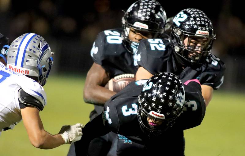 Woodstock North’s Braeden Berner, front, and Ian Slepcevich, middle, block a path for David Randecker, back, in varsity football at Woodstock North High School on Friday, October 24, 2025.