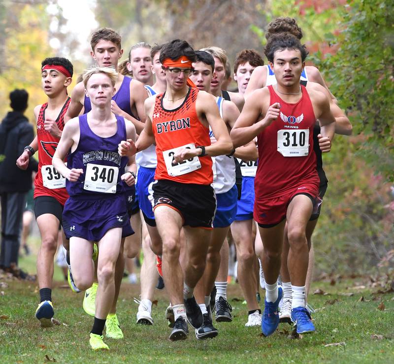 Byron's Tim Starwalt (center) checks his time as he leads the pack with Oregon's Daniel Gonzalez (right) at the 1A Winnebago Boys Regional on Saturday, Oct. 25, 2025 at the Levi and Ester Fuller Memorial Forest Preserve. Starwalt won the race 14:17 while Gonzalez placed 12th in 15:03.