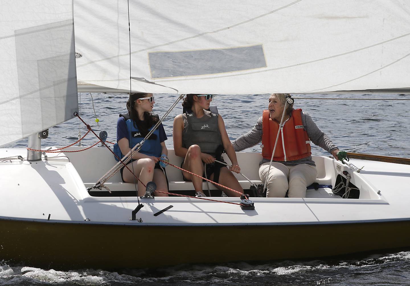 Betsy Alison, (right) a master trainer with US Sailing teaches Mary Ross (left) and Mackenzie Winkiel, (center) while sailing a Flying Scot sailboat during a US Sailing adaptive sailing class on Saturday, May 4, 2024, at the Pistakee Yacht Club's Community Sailing School in Johnsburg.