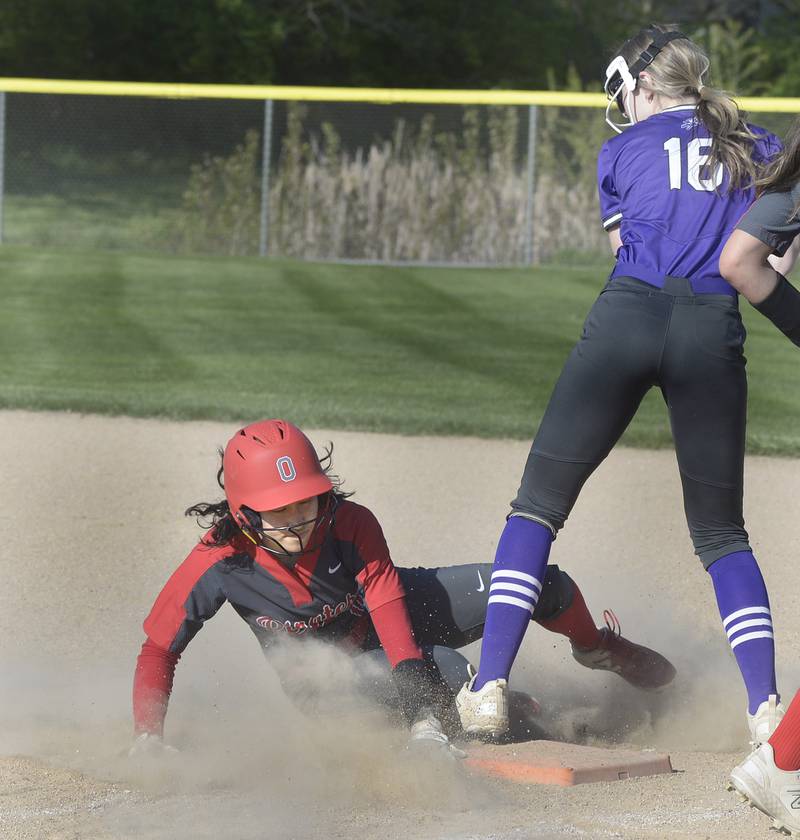 Trying to avoid being doubled up, Ottawa’s Mika Moreland dives into 1st base as Rochelle’s Briel Metzger takes the throw Wednesday at Ottawa.