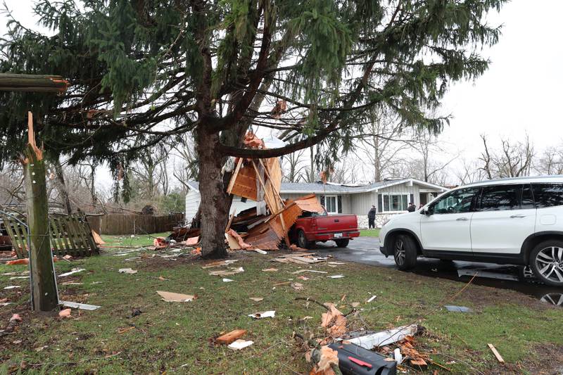 A portion of the roof hangs from a tree at the home of Connie Orozco on South East Marquette Lane in Aroma Park on March 11, 2026 following a March 10 tornado that passed through Kankakee County.